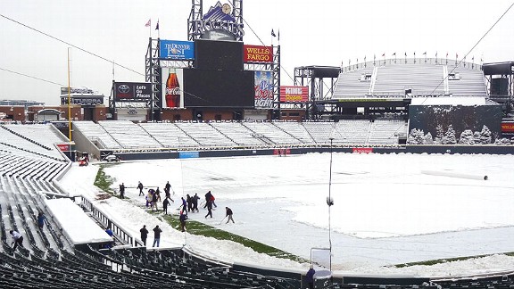 Rockies owner Dick Monfort and mascot Dinger help shovel snow from Coors Field