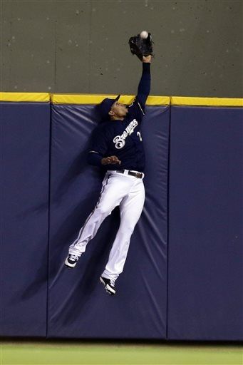  Carlos Gomez leaps above the wall in center to take a home run away from Carlos Gonzalez