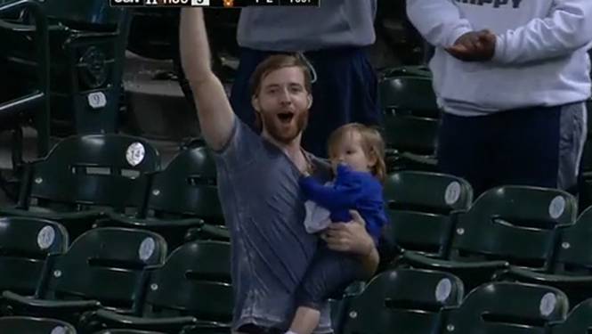 A fan holding a baby makes a great grab with his hat (Video)